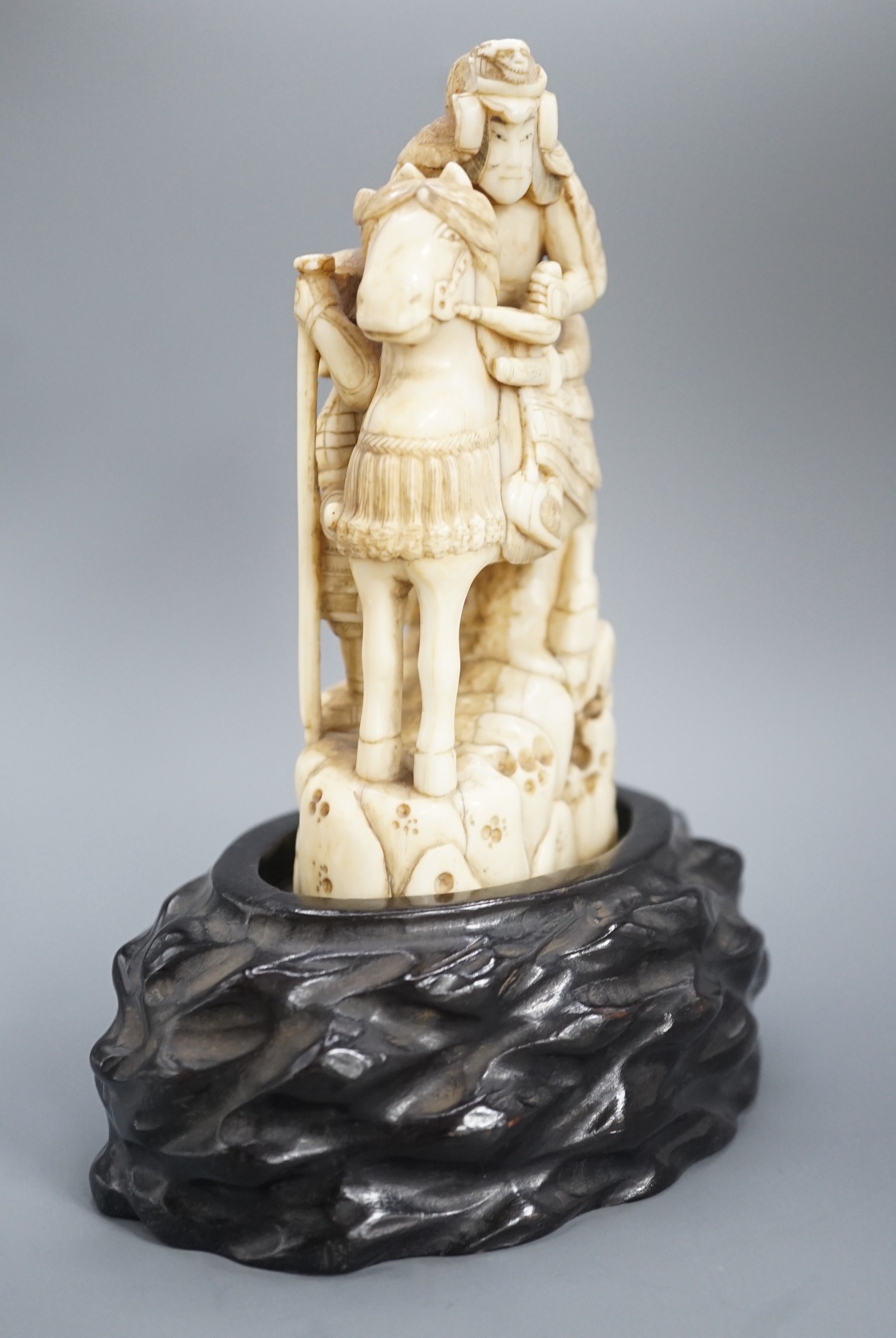 A Japanese ivory okimono of a samurai on horseback, with an attendant behind him, signed, late 19th century 12cm